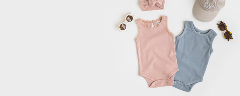 Organic cotton baby tank bodysuits in various colors displayed on neutral background