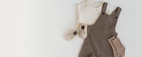 Baby in soft organic cotton overalls with easy snap buttons for comfortable crawling and play