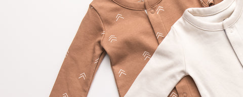 Soft organic cotton newborn coming home clothes laid out on white background